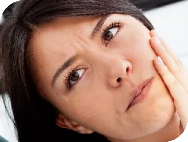 Woman with concerned expression holding cheek possibly indicating toothache or discomfort.
